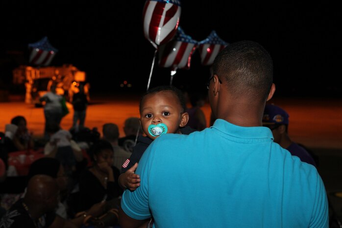 Annette Rall greets her husband, Cpl. Ethan Rall, upon his return from a seven-month deployment to Afghanistan. She then introduced Rall to their younest child, who was born during the deployment.