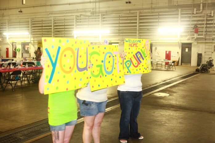 Kari Campbell (left) along with her sisters Jennifer (center) and Stephanie, await the return of the brother Cpl. Bradley Campbell from a seven-month deployment to Afghanistan at the Marine Heavy Helicopter Squadron 461 hangar, July 30.