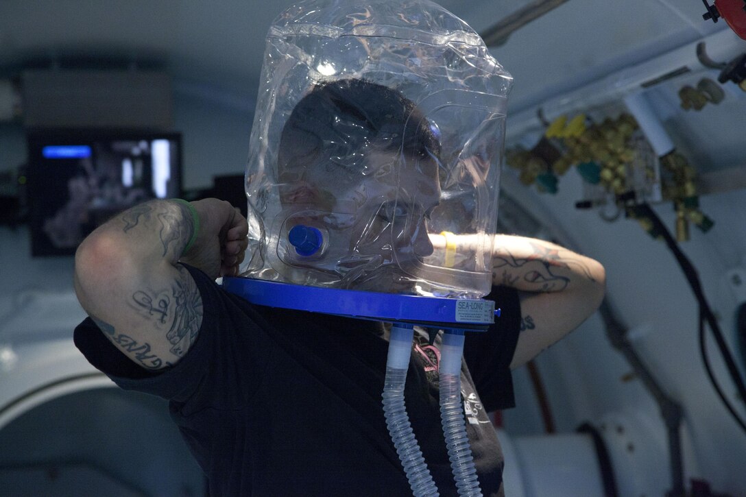 Dustin Halper, a site certified hyperbaric technologist at Naval Hospital Camp Lejeune, puts on an oxygen mask while inside a Hyperbaric Oxygen Multiplace Chamber aboard Marine Corps Base Camp Lejeune Aug. 8.  The multiplace chamber is capable of fitting six people while pressurizing the inside to an equivalent of 17 feet underwater.
Find us on Google + (http://gplus.to/camp.lejeune)
Follow us on Twitter (http://twitter.com/camp_lejeune)
Like us on Facebook (http://www.facebook.com/camp.lejeune) 