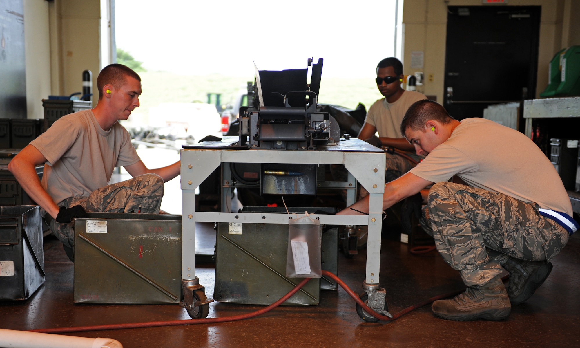 U.S. Air Force Airmen 1st Class Tyler Peterson, left, Junu Johnny, back right, and Senior Airman Ben Staples, 35th Maintenance Squadron, unload 20mm rounds from a Universal Ammunition Loading System at Misawa Air Base, Japan, Aug. 14, 2013. Ammo Airmen load the UALS with 1,525 rounds, which are then taken to the flightline and loaded onto F-16 Fighting Falcons. (U.S. Air Force photo by Senior Airman Kia Atkins)