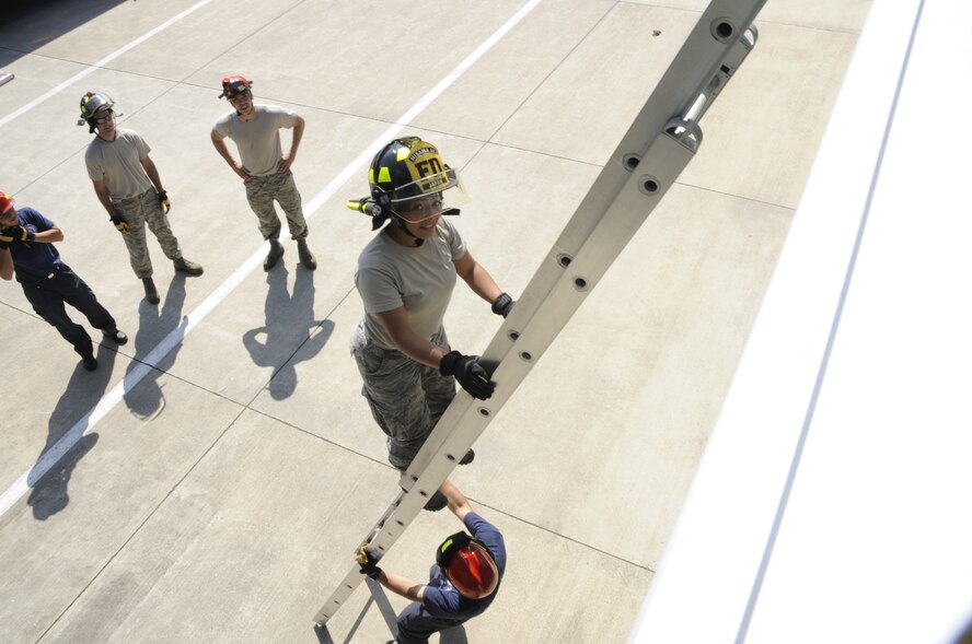 Airman 1st Class Hillary Brock, 35th Civil Engineer Squadron firefighter, practices climbing an extension ladder at Misawa Air Base, Japan, Aug. 12, 2013. As a member climbs an extension ladder, another member must hold and secure it in place to ensure safety and prevent injury. (U.S. Air Force photo by Airman 1st Class Kaleb Snay)