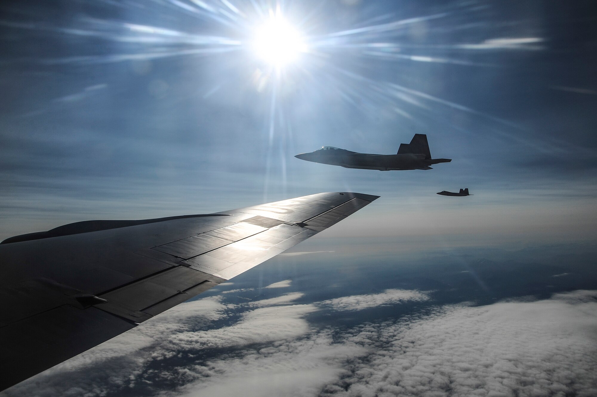 Two U.S. Air Force F-22 Raptors from Joint Base Elmendorf-Richardson, Alaska, fly alongside a KC-135 Stratotanker from Kadena Air Base, Japan, over the Joint Pacific Alaska Range Complex during RED FLAG-Alaska 13-3 Aug. 14, 2013. More than 60 aircraft and 2,600 personnel are participating in the two-week RF-A exercise. (U.S. Air Force photo by Senior Airman Zachary Perras/Released)