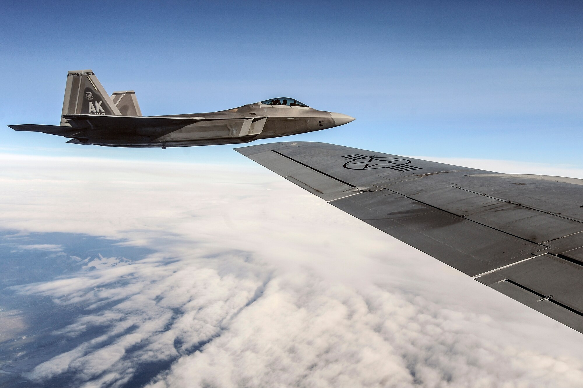 A U.S. Air Force F-22 Raptor from Joint Base Elmendorf-Richardson, Alaska, flies alongside a KC-135 Stratotanker from Kadena Air Base, Japan, over the Joint Pacific Alaska Range Complex during RED FLAG-Alaska 13-3 Aug. 14, 2013. The JPARC is comprised of extensive military operations areas, special use airspace and ranges for a total of more than 67,000 square miles of airspace. (U.S. Air Force photo by Senior Airman Zachary Perras/Released)