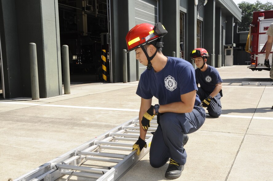 Shota Sotokawa, left, and Keisuke Kawamura, 35th Civil Engineer Squadron firefighters, practice proper ladder lifting at Misawa Air Base, Japan, Aug. 12, 2013. Members must use teamwork to be the most efficient when out on real-world missions as someone’s life may depend on it. (U.S. Air Force photo by Airman 1st Class Kaleb Snay)