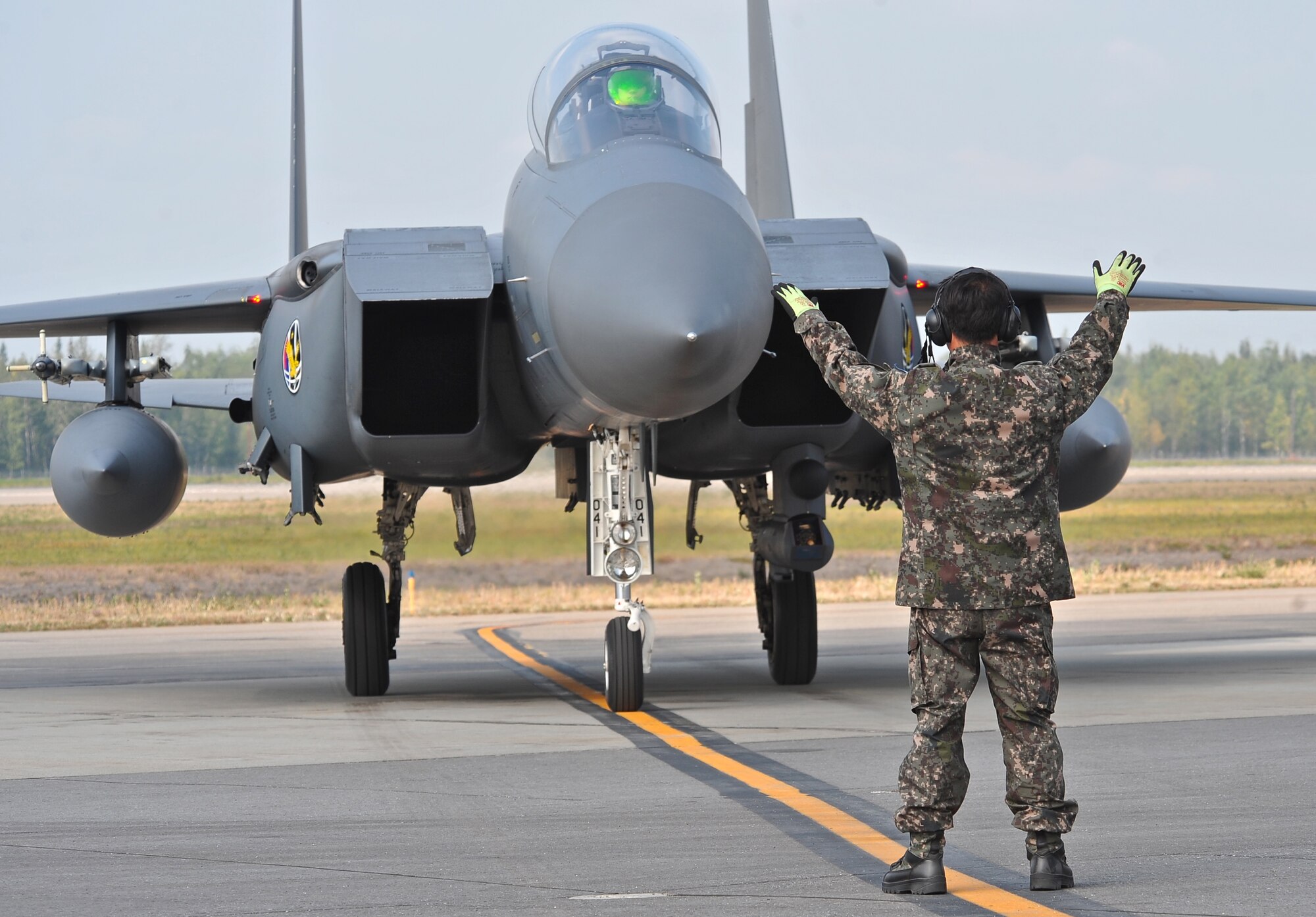 A Republic of Korea Air Force crew chief marshals an F-15K Slam Eagle for parking after a morning mission during RED FLAG-Alaska 13-3 Aug. 12, 2013, Eielson Air Force Base, Alaska.  This is the first time the ROKAF are participating in the Pacific Air Forces-sponsored, Joint National Training Capability accredited exercise. (U.S. Air Force photo by Staff Sgt. Miguel Lara/Released)
