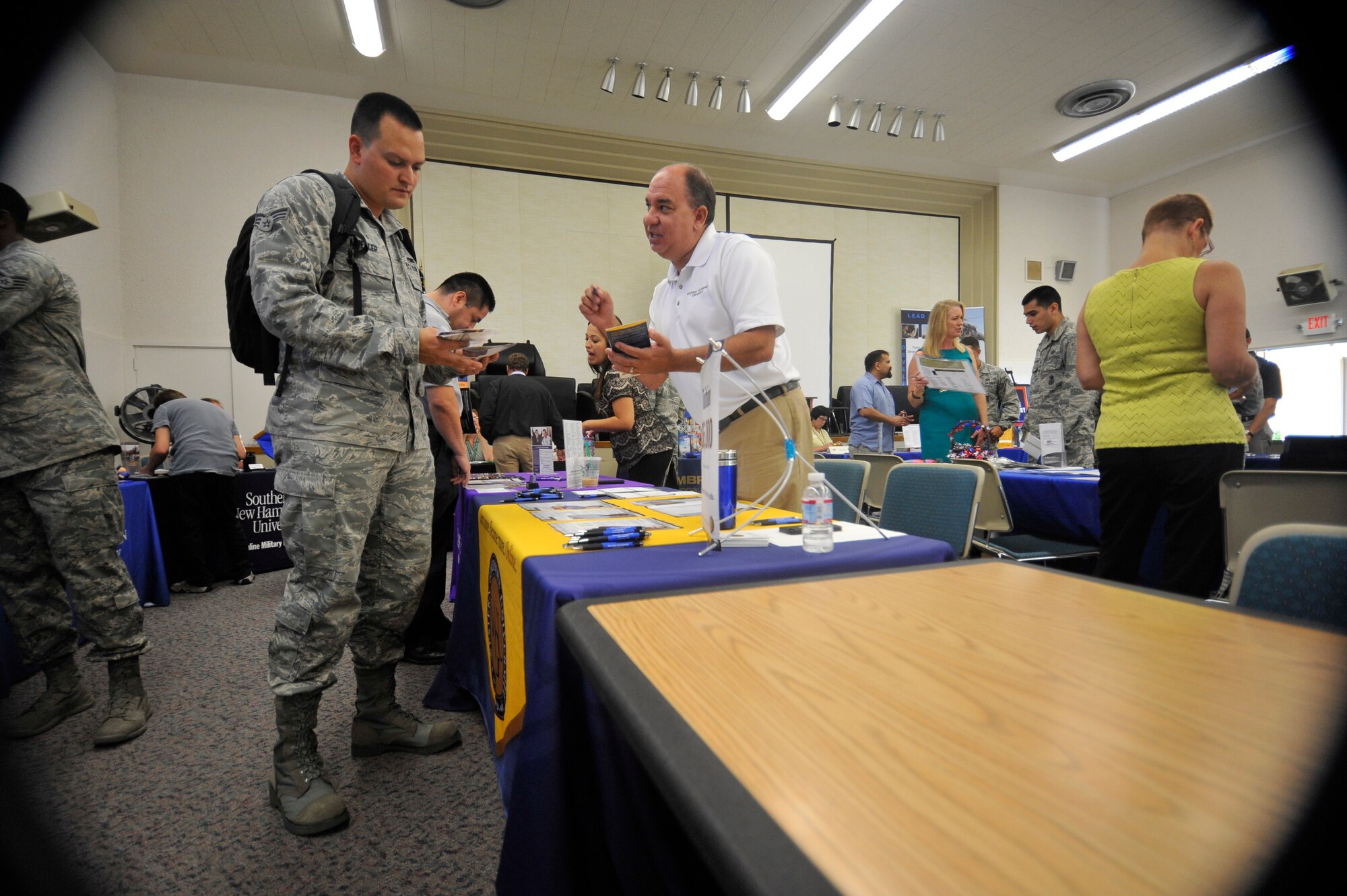 VANDENBERG AIR FORCE BASE, Calif. -- Senior Airman Joseph Mueller, 30th Force Support Squadron outbound assignments member, speaks with a university representative about educational opportunities available to him during an education fair here Thursday, August 15, 2013. The 30th Force Support Squadron's Education Center hosts this annual event, inviting educational institutions from across the country to Vandenberg, to provide Team V a one-stop venue to research their educational pursuits. (U.S. Air Force photo/Michael Peterson)