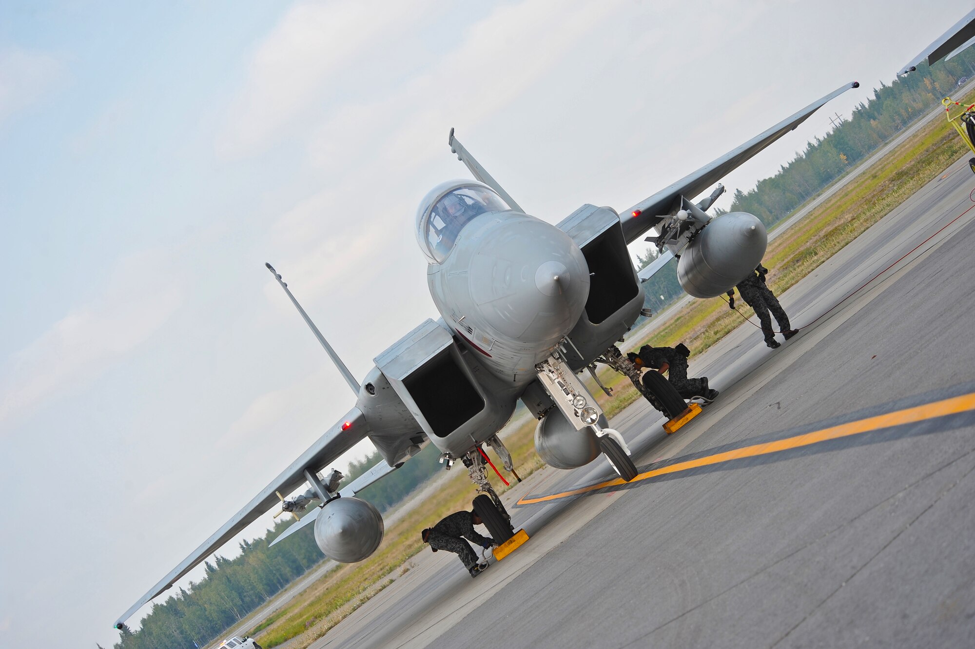 Japan Air Self Defense Force crew chiefs lay chock down as an F-15 Eagle recovers from a morning sortie during RED FLAG-Alaska 13-3 Aug. 12, 2013, Eielson Air Force Base, Alaska.  RF-A, a two-week exercise, focuses on aerial combat training for U.S. and allied forces and is conducted within the Joint Pacific Alaska Range Complex, a 67,000 square mile training range.(U.S. Air Force photo by Staff Sgt. Miguel Lara/Released)