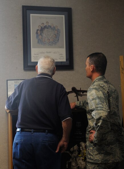 U.S. Air Force Maj. Jason Kalin, 509th Logisitics Readiness Squadron commander, shows former Chief Master Sgt. of the Air Force Robert Gaylor a photo signed by all the CMSAFs he received as a young enlisted Airman, Aug. 8, 2013, Whiteman Air Force Base, Mo. Kalin was a senior airman working the annual command chief conference at Maxwell-Gunter Air Force Base, Ala., when he received it. (U.S. Air Force photo by Staff Sgt. Alexandra M. Boutte/Released)