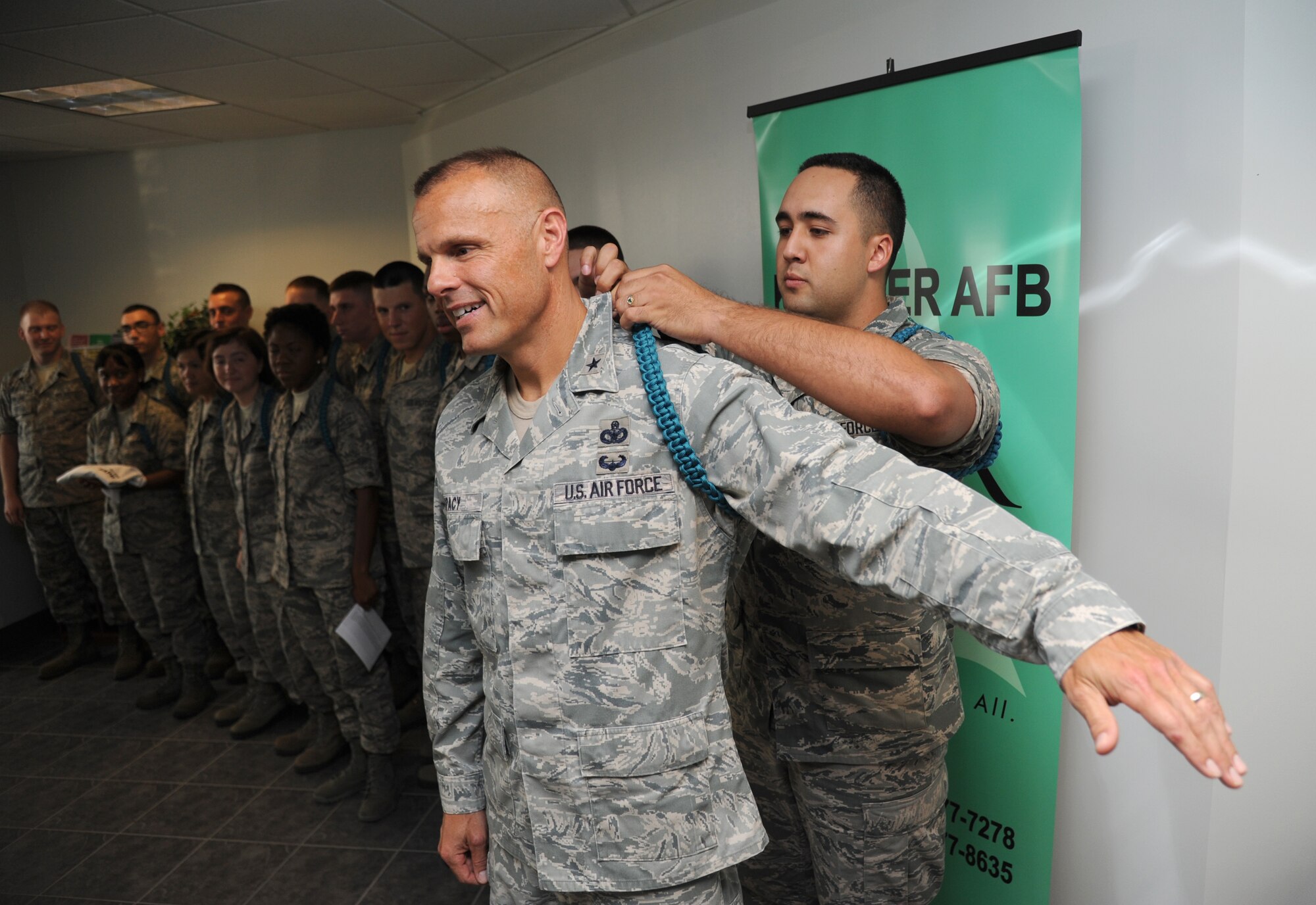 Brig. Gen. Brad Spacy, 81st Training Wing commander, receives a teal rope from Airman Basic Joshua Garretson, 336th Training Squadron, during a presentation making Spacy an honorary 81st TRW Teal Rope member Aug. 15, 2013, at Dolan Hall, Keesler Air Force Base, Miss.  (U.S. Air Force photo by Kemberly Groue)