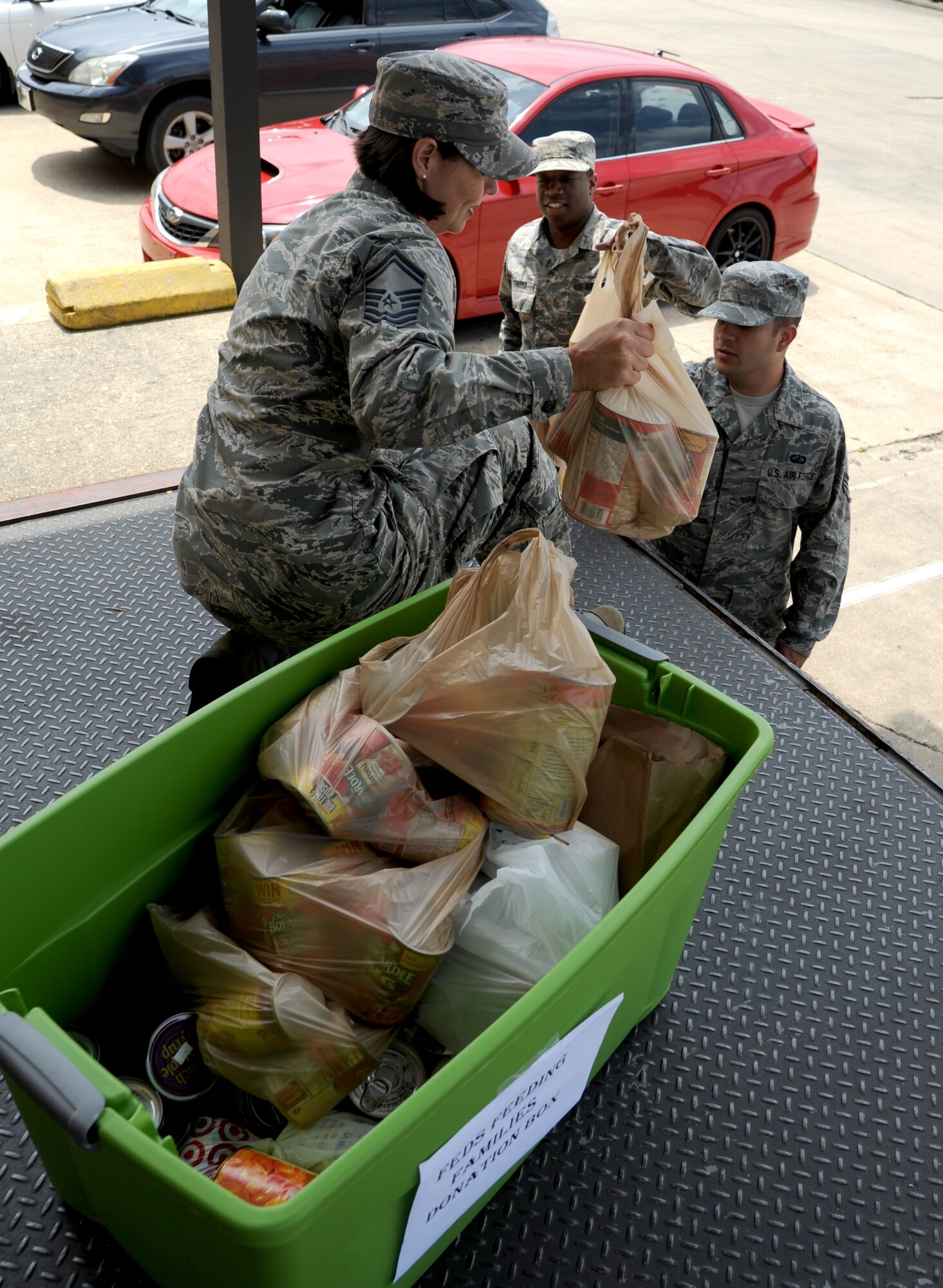 Senior Master Sgt. Dean’na Hoy, 335th Training Squadron and a project officer for Keesler’s Feds Feed Families Campaign, receives perishable food items from Staff Sgts. Justin Cheeks and Thomas Hutchins, 81st Contracting Squadron, that their squadron collected for the campaign Aug. 15, 2013, at the Taylor Logistics Center loading dock, Keesler Air Force Base, Miss. The campaign will continue thru Aug. 31 and all donations will be delivered to Back Bay Mission in Biloxi, Miss., Sept. 2.  (U.S. Air Force photo by Kemberly Groue)