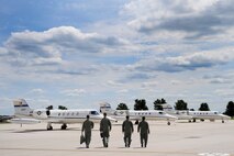 Aircrew members from the 375th Operations Group walk towards a row of C-21's Aug. 15, 2013, Scott Air Force Base, Ill. The C-21 is used for cargo and passenger airlift and has the ability to provide aeromedical evacuations. (U.S. Air Force photo/Staff Sgt. Christopher Boitz)
