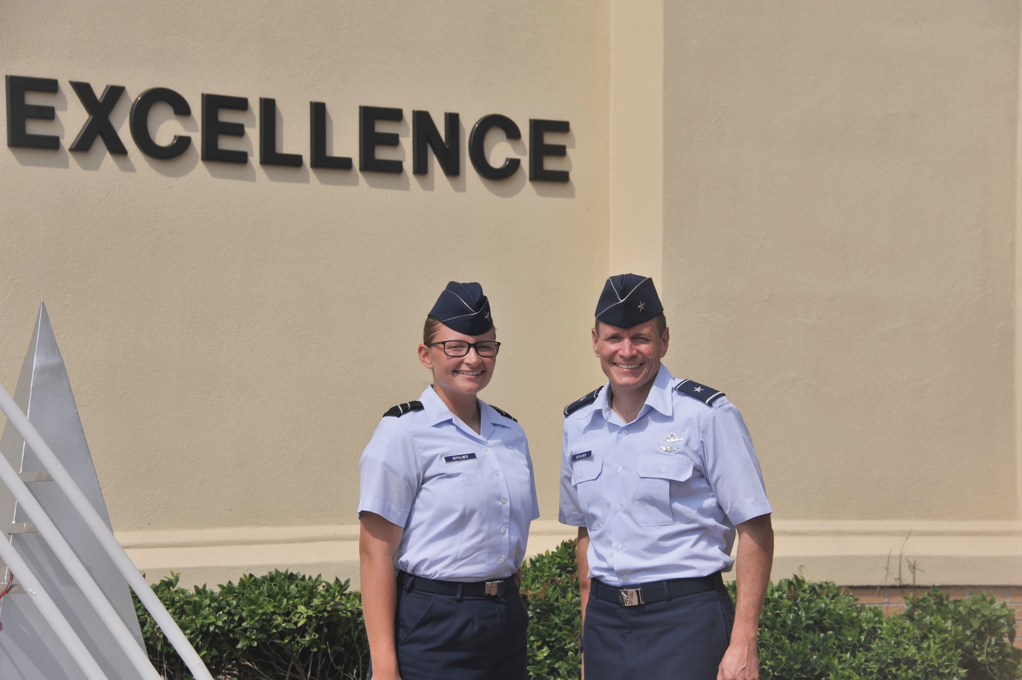 Brigadier Gen. Steve DePalmer, deputy director, Joint Interagency Task Force South, U.S. Southern Command, and his daughter, Air Force Reserve Officer Training Corps Cadet Devin DePalmer, stand outside of the Officer Training School building Aug. 6.  The general surprised his daughter by attending her graduation from AFROTC field training and presenting her with a Prop and Wings pin signifying entry into the professional officer course. (U.S. Air Force photo by Staff Sgt. Gregory Brook)