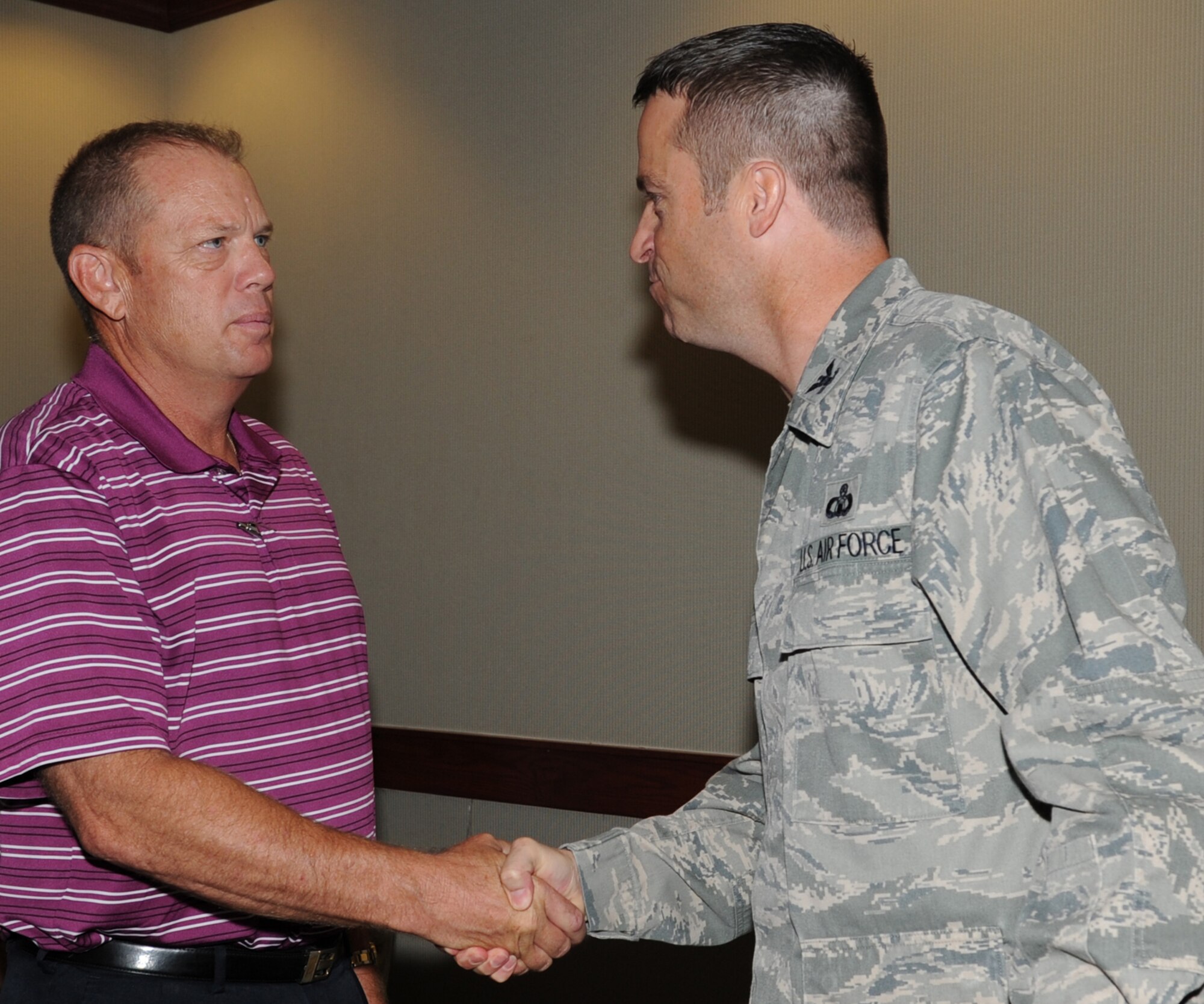 GOODFELLOW AIR FORCE BASE, Texas -- Wayne Click, 17th Civil Engineer Squadron Readiness and Emergency Management Flight Chief, receives a coin from Col. Thomas Schmidt, 17th Training Wing Vice Commander, for winning the 2012 Air Education and Training Command Emergency Management Manager of the Year Award Aug. 13. Nominees are judged on several criteria including their accomplishments, job performance, technical competence, leadership ability and initiative to earn the AETC Emergency Management Civilian Manager of the Year Award, (U.S. Air Force photo/ Staff Sgt. Laura R. McFarlane)
