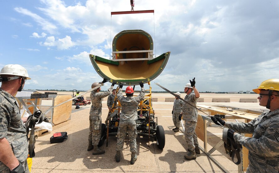 Crew chiefs from the 2nd Aircraft Maintenance Squadron secure a B-52H Stratofortress radome to a lift using a sling created by 2nd Maintenance Squadron fabrication flight on Barksdale Air Force Base, La., Aug. 13, 2013. The sling made it easier for crew chiefs to repair, transport and remove the radome. (U.S. Air Force photo/Senior Airman Sean Martin)