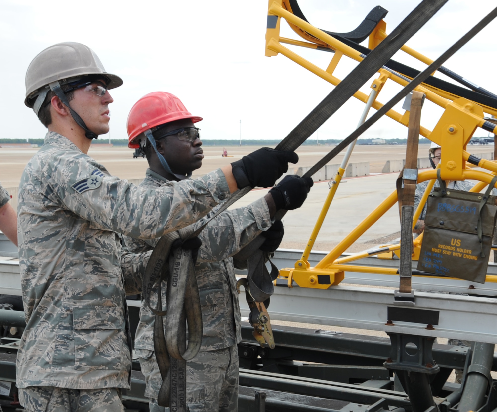Senior Airman Jacob Andrews, 2nd Aircraft Maintenance Squadron crew chief, and Senior Airman Keith Jackson, a reservist assigned to the 2nd AMXS, hold straps attached to a B-52H Stratofortress radome on Barksdale Air Force Base, La., Aug. 13, 2013. The sling is able to rotate 360 degrees, making it easier for Airmen to transport. (U.S. Air Force photo/Senior Airman Sean Martin)
