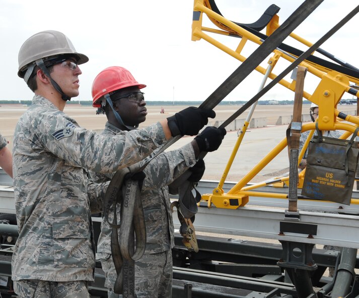 Senior Airman Jacob Andrews, 2nd Aircraft Maintenance Squadron crew chief, and Senior Airman Keith Jackson, a reservist assigned to the 2nd AMXS, hold straps attached to a B-52H Stratofortress radome on Barksdale Air Force Base, La., Aug. 13, 2013. The sling is able to rotate 360 degrees, making it easier for Airmen to transport. (U.S. Air Force photo/Senior Airman Sean Martin)