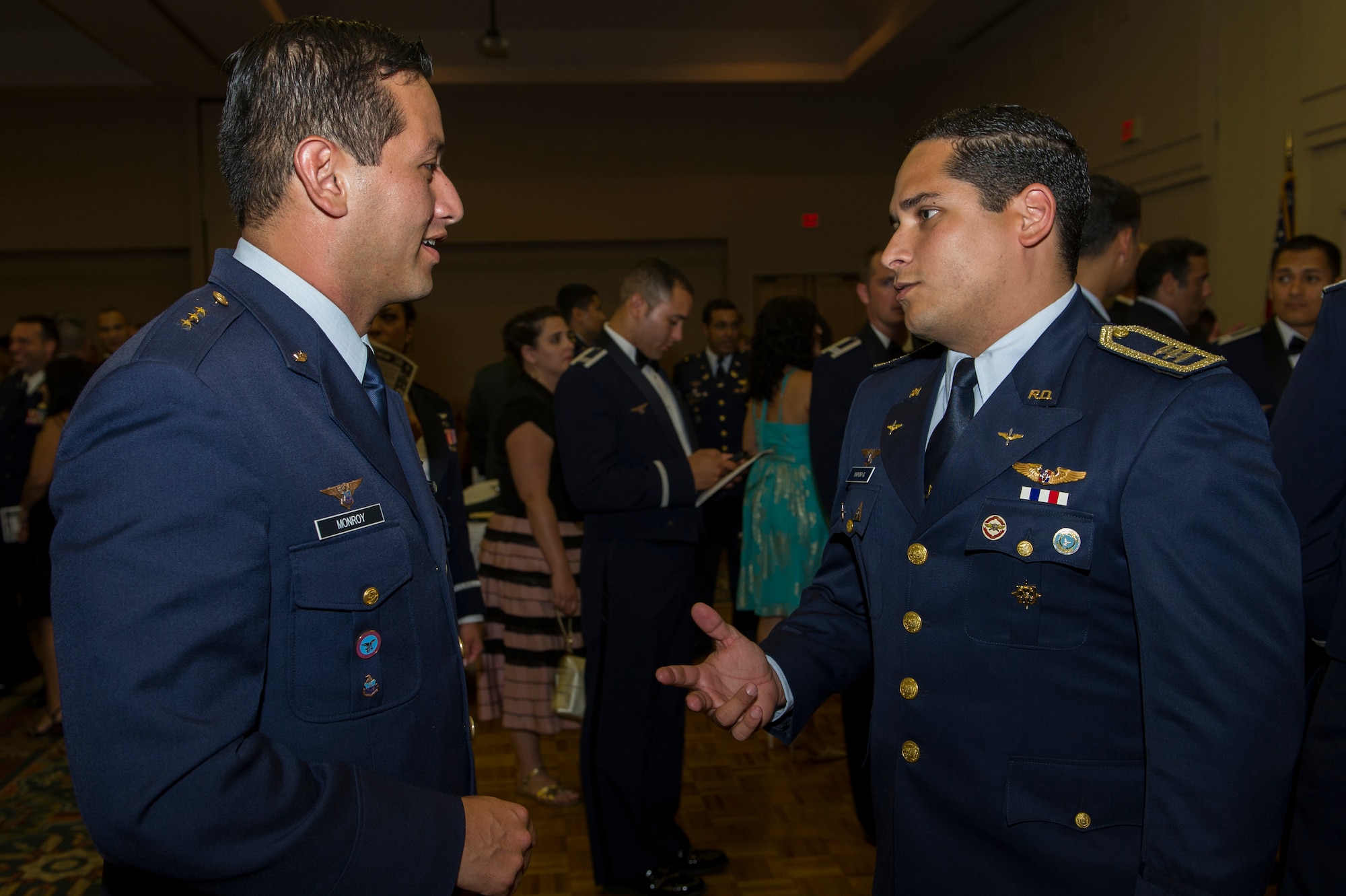 Capt. Carlos Monroy (left), Colombia air force internal control offi cer, talks with Capt. Daniel Yapor, Dominican Republic air force pilot, after the Inter-American Air Forces Academy graduation banquet July 31. Monroy and Yapor met through the IAAFA  International Squadron Officers School Professional Military Education class at Joint Base San Antonio-Lackland.