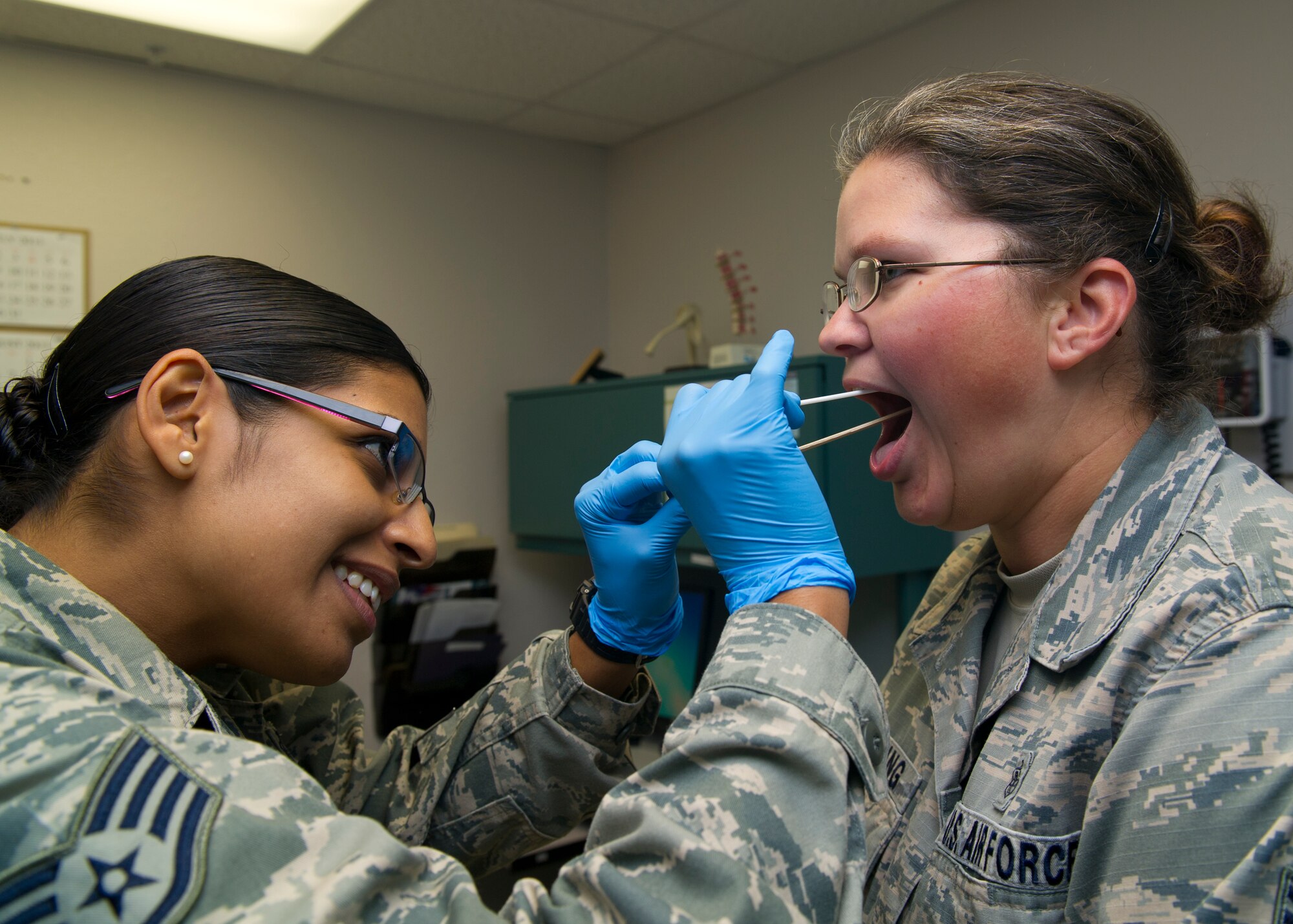 Staff Sgt. Castillo Ironne, 49th Medical Group aerospace medicine craftsman, performs a throat culture on a patient at Holloman Air Force Base, N.M., Aug. 14. The 49th MDG has 13 sections that work directly with patients and serves over 14,000 beneficiaries. The group employs 222 active-duty and civilian personnel with various jobs supporting the medical needs of Team Holloman. (U.S Air Force photo by Airman 1st Class Leah Murray/Released)