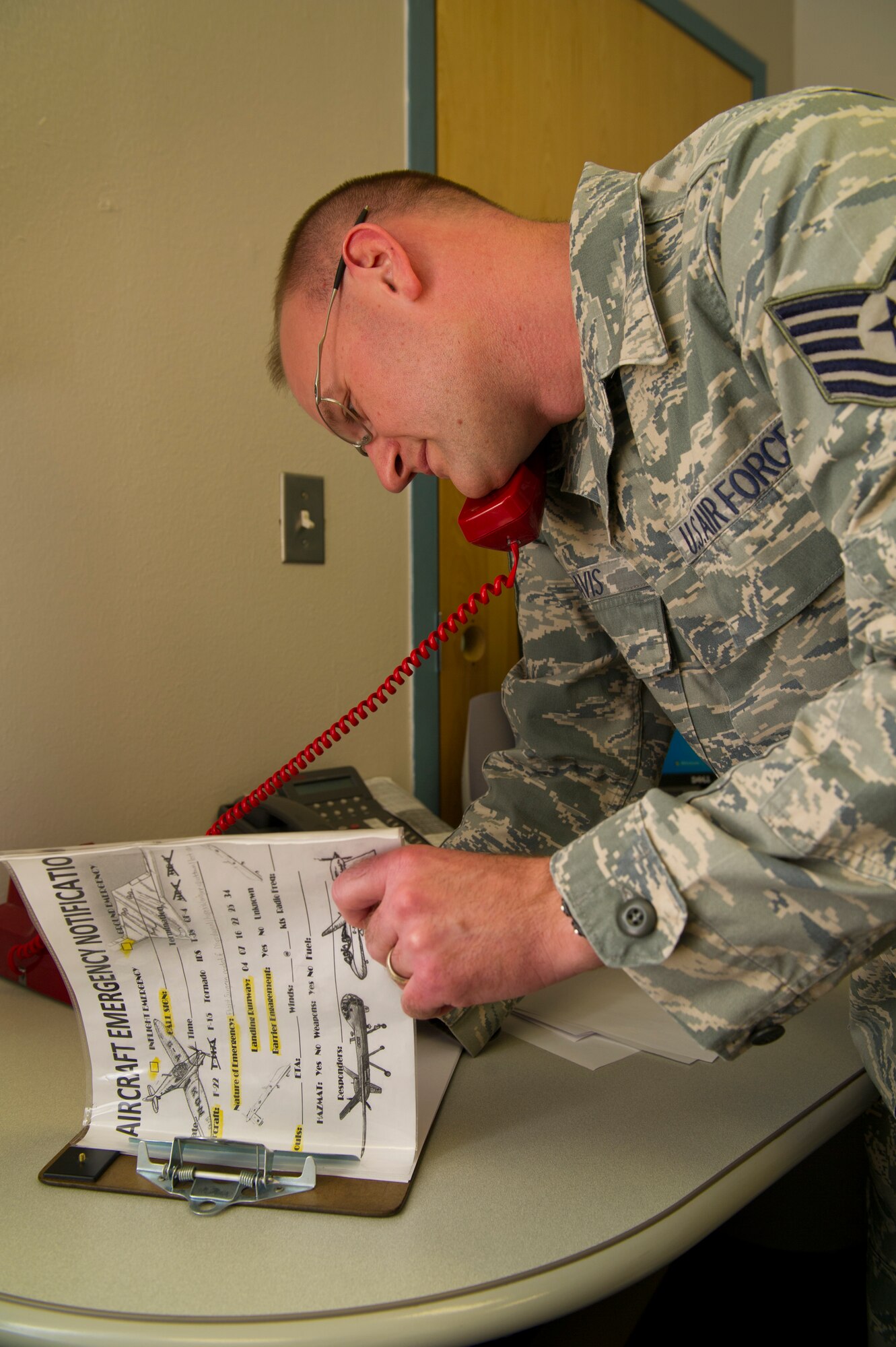 Technical Sgt. Cameron Davis, 49th Medical Group aerospace medicine flight chief answers the crash phone at Holloman Air Force Base, N.M., Aug. 14. The 49th MDG has 13 sections that work directly with patients and serves over 14,000 beneficiaries. The group employs 222 active-duty and civilian personnel with various jobs supporting the medical needs of Team Holloman. (U.S Air Force photo by Airman 1st Class Leah Murray/Released)

