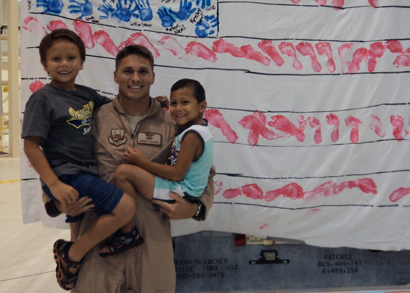 U.S. Air Force Capt. Jeremy Stover poses for a photo with his sons after returning from his second deployment to Southwest Asia. Stover served as the senior weapons system office on-board Bone-34, which was recently awarded the 2012 Gen. Curtis E. LeMay Outstanding Bomber Aircrew Award. (Courtesy photo)