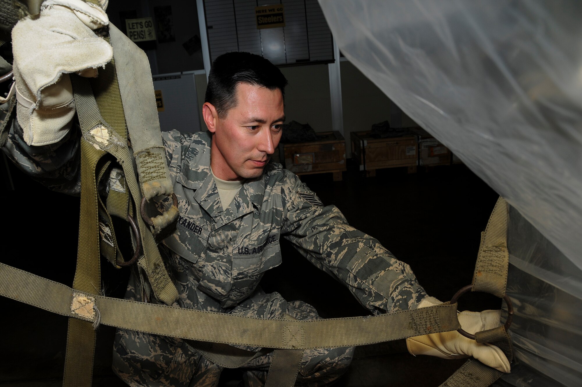 Tech Sgt. Peter Alexander, 911th Aeromedical Staging Squadron medical supplies and logistics technician, secures a pallet of deployment equipment with a strap net during pallet build-up training at the Pittsburgh International Airport Air Reserve Station, Aug. 10 2013. The training was conducted to help insure every unit has at least six personnel trained in building pallets for maintaining unit deployment readiness. Properly building pallets ensures equipment is secured, accounted for and mission ready when received at deployed locations. (U.S. Air Force photo by Senior Airman Joshua J. Seybert)