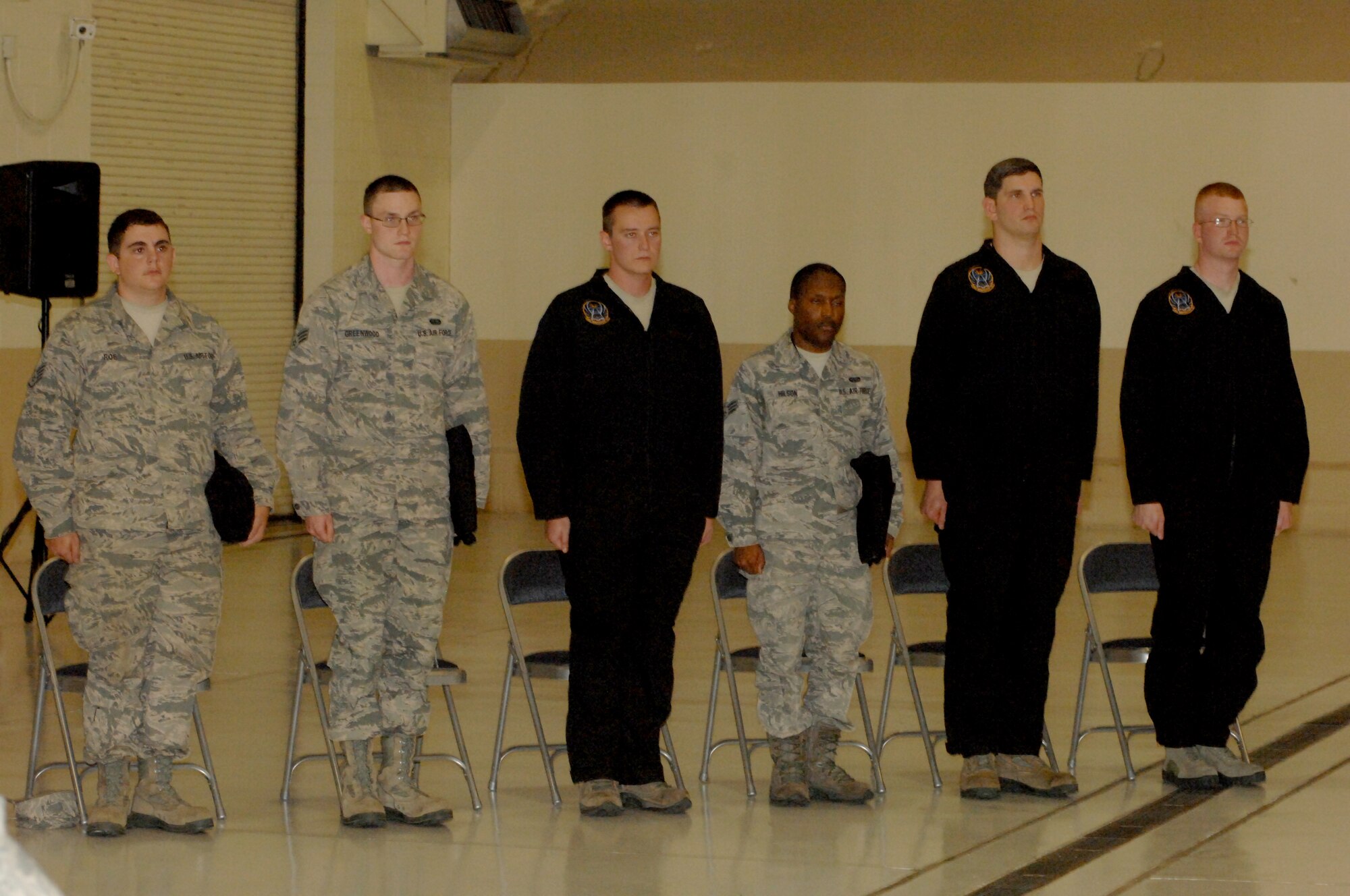 More than a dozen crew chiefs from the 69th Maintenance Squadron, stand at attention as they prepare to be officially named dedicated crew chiefs (DCC) during a special ceremony, which took place Aug. 5, 2013, in one of the hangar at Grand Forks Air Force Base, N.D. The title of DCC and the black coveralls officially acknowledges that an individual is a maintenance expert on their respective aircraft. (U.S. Air Force photo/Staff Sgt. Susan Davis)