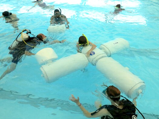 Students build an International Space station model in the Kirtland indoor swimming pool Aug. 2. The students built a 22-foot model in water to simulate then microgravity conditions found in outer space. The activity was part of the Air Force Research Laboratory La Luz Academy's summer camp. (Photo by Stephen Burke)