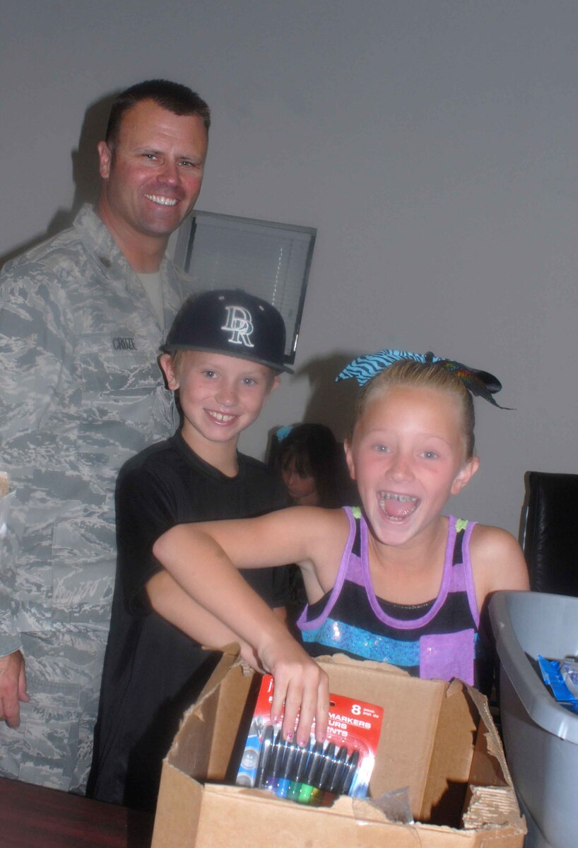 Ashlyn Cruze, foreground, is ecstatic to receive school supplies during Operation Homefront’s Back-to-School Brigade campaign held Aug. 3 at the Nevada Air Guard base in Reno. Ashlyn attended the event with her father, Maj. Shaun Cruze, and brother, Seth Cruze. More than 500 northern Nevada students received school supplies during the Back-to-School Brigade campaign.  NV ANG photo by Master Sgt. Suzanne Connell (released).