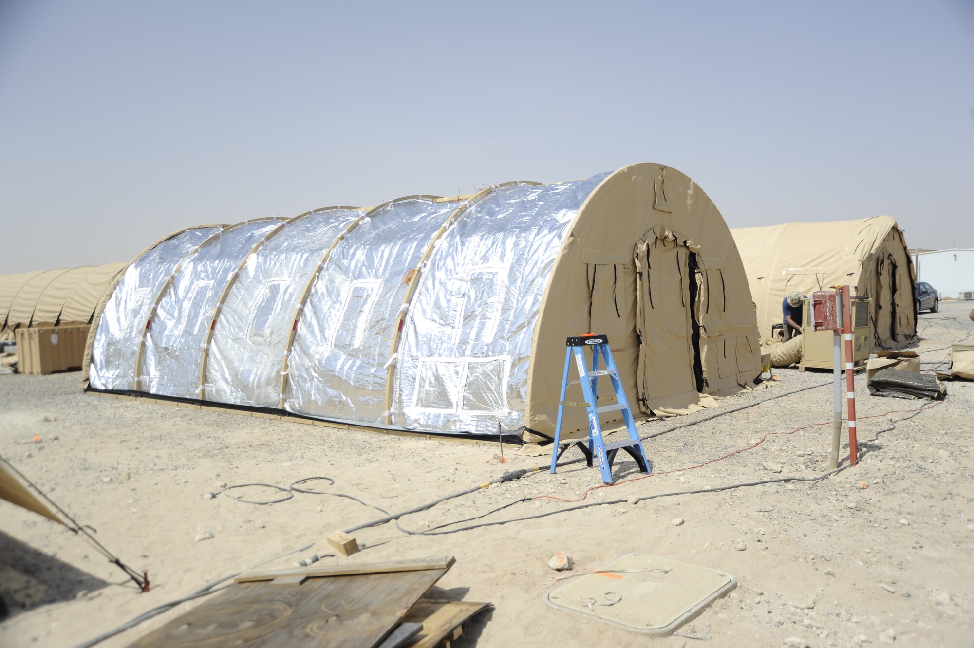 SOUTHWEST ASIA -- A tent with a reflective covering is installed at a base here as part of a joint research project between the Air Force and Army to test energy saving technologies in the AOR. The tents include insulated liners, photovoltaic flys and more efficient environmental control units. The project will monitor the energy-saving capabilities of the new technologies over the next year. (U.S. Air Force photo/Master Sgt. Christopher Campbell)