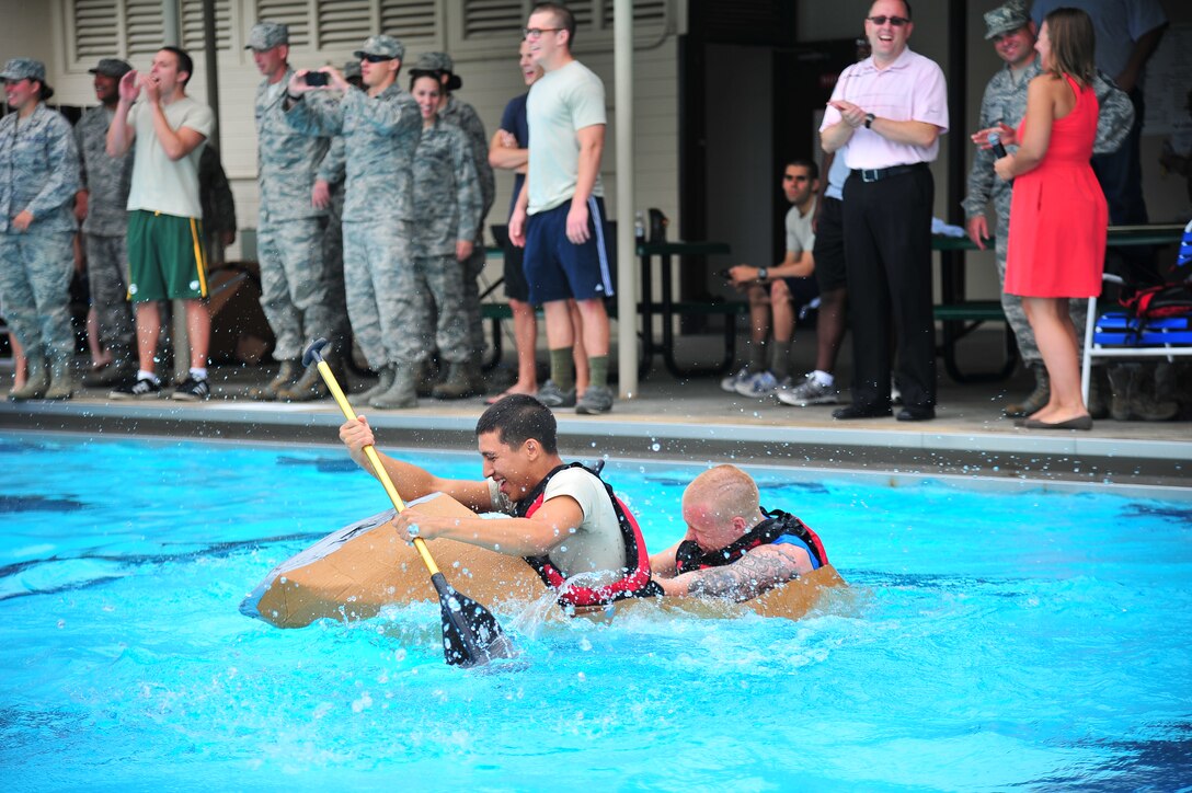 Airmen 1st Class Thomas Siena and Dakota James, 4th Component Maintenance Squadron aerospace propulsion specialists, struggle to stay afloat during the Build-a-Boat competition at Seymour Johnson Air Force Base, N.C., Aug. 14, 2013. Several teams’ cardboard and duct tape ships couldn’t withstand the weight of their crews and sunk at the start of the races. (U.S. Air Force photo by Senior Airman Aubrey White/Released)