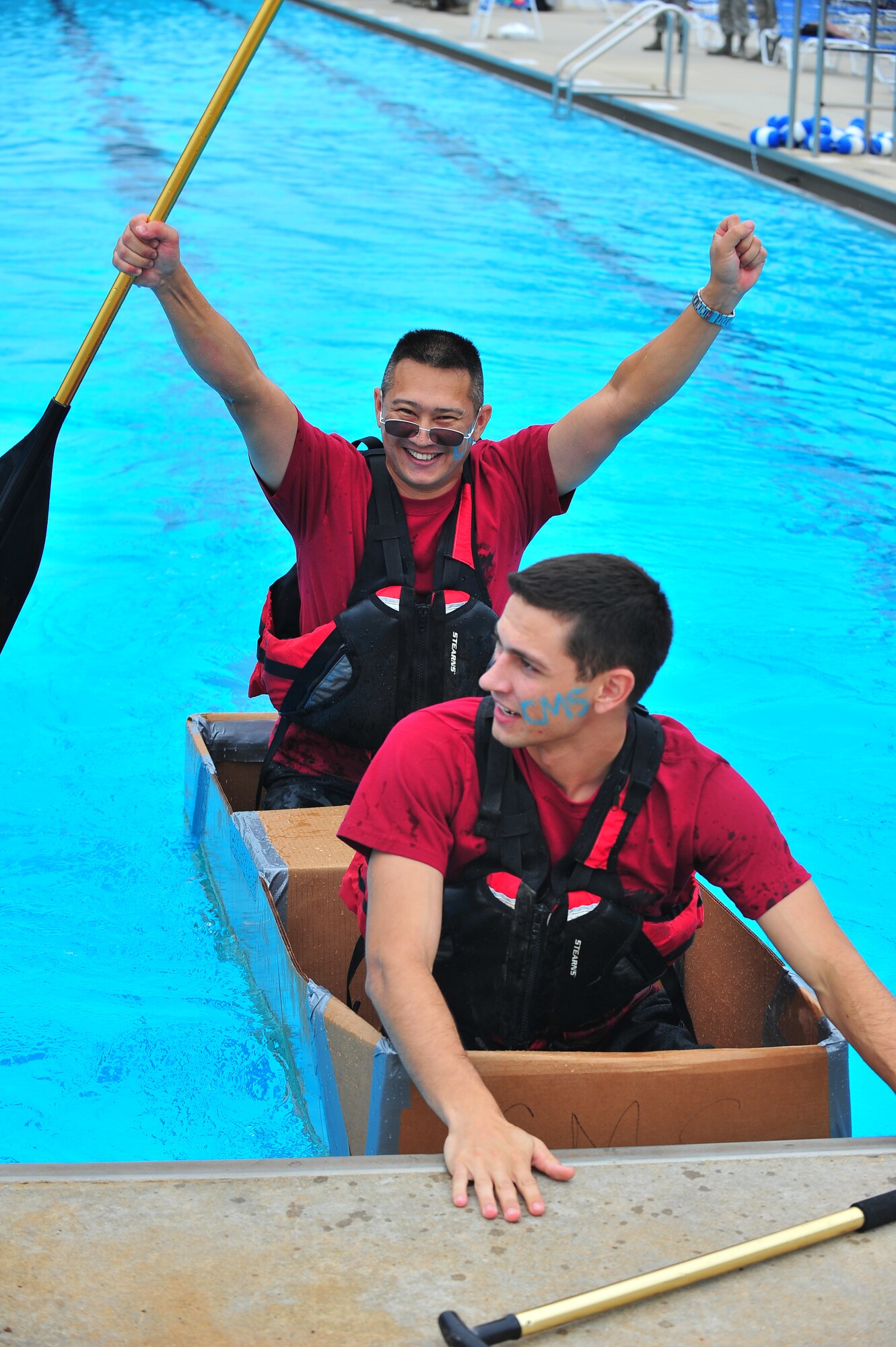 U.S. Air Force Tech. Sgt. Richard Plue, 4th Component Maintenance Squadron resource advisor, celebrates as he and Airman 1st Class Cameron Crawford, 4th CMS knowledge operations manager, complete a race during the Build-a-Boat competition at Seymour Johnson Air Force Base, N.C., Aug. 14, 2013. The team named their boat “Source This” and completed the race in 49 seconds. (U.S. Air Force photo by Senior Airman Aubrey White/Released)