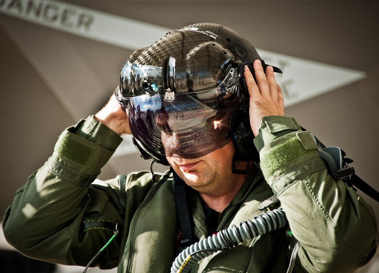 Lt. Cdr. Chris Tabert puts on the specialized helmet before piloting the first F-35C Lightning II flight at Eglin Air Force Base Aug. 14. Before arriving to U.S. Navy F-35 Strike Fighter Squadron VFA 101 in February, he served as a test pilot for the joint strike fighter program at Naval Air Station Patuxent River. He will become the squadron's first instructor pilot and join a collocated team of Marine, Navy, Air Force and international partners training here.  (U.S. Air Force photo/Samuel King Jr.) 

