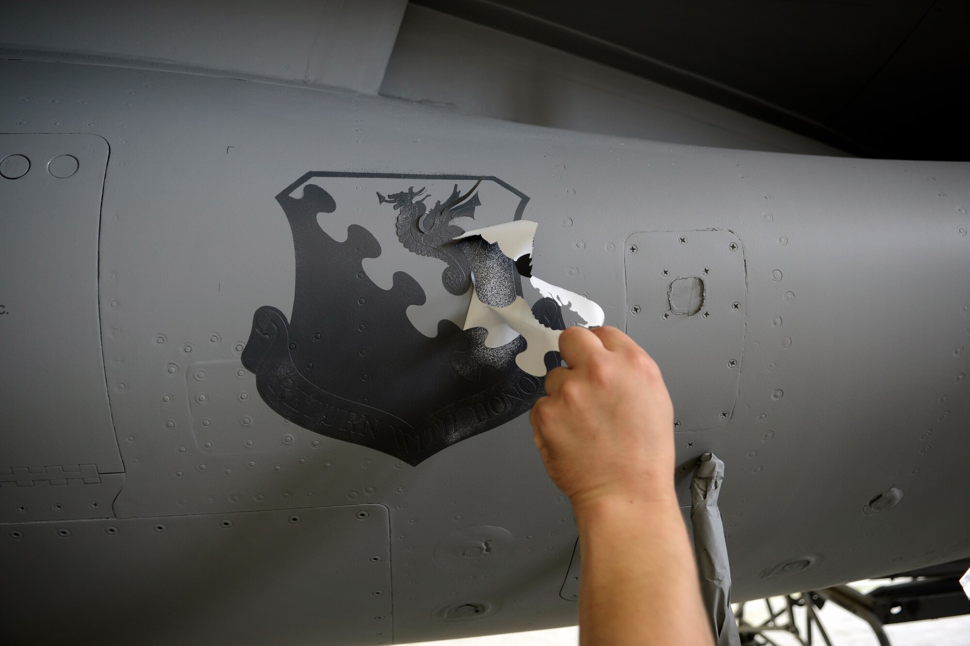 A decal is removed from an F-16 Fighting Falcon Aug. 13, 2013 at Aviano Air Base, Italy. Corrosion control technicians create, print and cut all decals that are applied to the aircraft. (U.S. Air Force photo/Senior Airman Jessica Hines) 