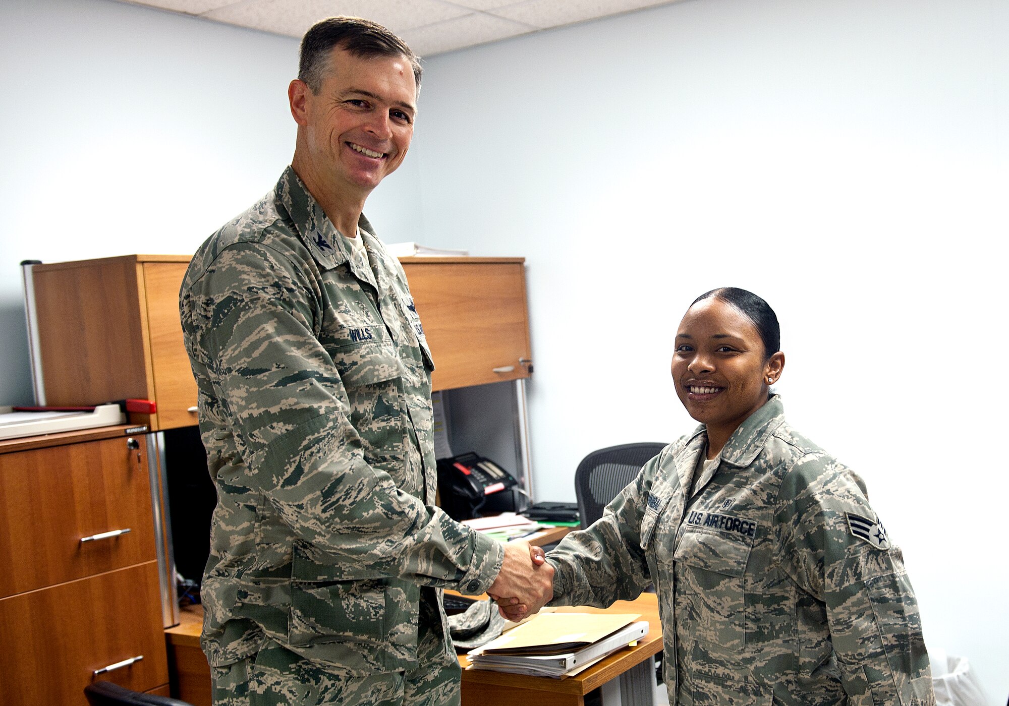 Col. Craig Wills, 39th Air Base Wing commander, presents a coin to Senior Airman Natasha Hannibal, 39th Medical Support Squadron medical technician, Aug. 15, 2013, at Incirlik Air Base, Turkey. Hannibal was awarded for her hard work and dedication to Incirlik Airmen and family members. (U.S. Air Force photo by Senior Airman Daniel Phelps/Released)