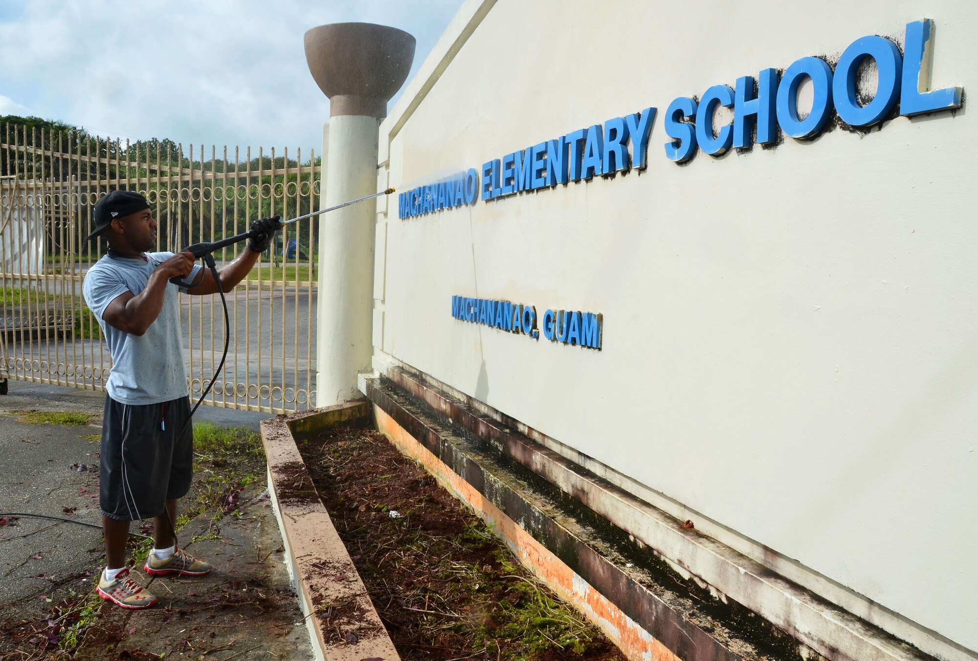 YIGO, Guam—Tech. Sgt. Bryan Johnson, 36th Force Support Squadron lodging superintendent, pressure-washes an entrance sign during a school beautification project at the Machananao Elementary School in Yigo, Guam, Aug. 14, 2013. Members of Team Andersen joined forces with U.S. Army units to assist Machananao Elementary and other schools in the community with restoration, landscaping and trash clean-up before the start of the school year. (U.S. Air Force photo by Staff Sgt. Benjamin Wiseman/Released)