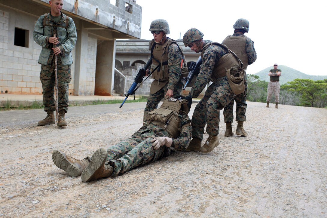 Marines evacuate a mock casualty to a casualty collection point after a simulated improvised explosive device detonation during the III Marine Expeditionary Force Headquarters Group Corporals’ Course culminating event Aug. 5 at the Combat Town training facility in the Central Training Area. As part of the event, the instructors set up simulated IEDs throughout the town and the students had to successfully identify the devices and use their radios to call in a nine-line report. The Marines are with various units within III MEF. III MHG is a part of III MEF. Photo by Sgt. Brian A. Marion