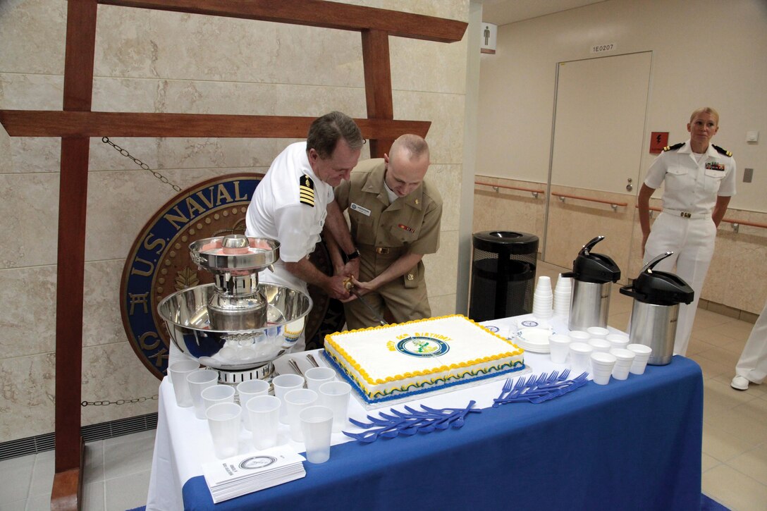 Navy Capt. Richard D. Hayden, left, and Lt. j.g. Daniel L. Anderson cut a birthday cake Aug. 5 at U.S. Naval Hospital Okinawa in celebration of the 66th anniversary of the Medical Service Corps. The ceremony involved the most senior officer, Hayden, and the most junior officer, Anderson, cutting the ceremonial cake. Anderson is a physician’s assistant with USNH Okinawa, and Hayden is a laboratory technician with USNH Okinawa. Photo by Lance Cpl. Pete Sanders
