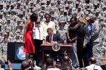 President Barack Obama signs an executive order preventing scams used to con veterans out of their federal education benefits, at Fort Stewart, Ga., April 27, 2012, as First Lady Michelle Obama and Fort Stewart Soldiers and civilians look on.