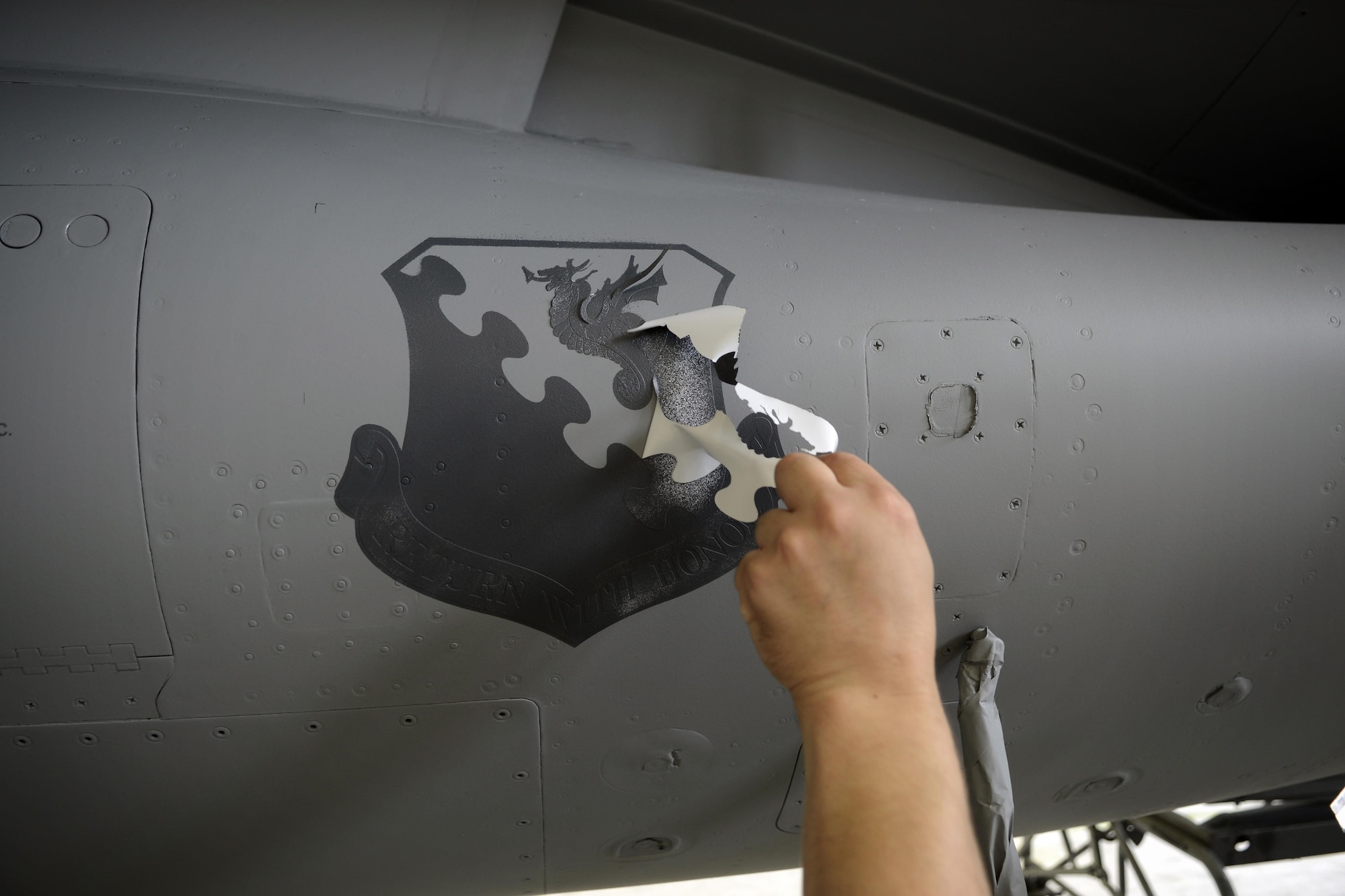 A decal is removed from an F-16 Fighting Falcon Aug. 13, 2013 at Aviano Air Base, Italy. Corrosion control technicians create, print and cut all decals that are applied to the aircraft. (U.S. Air Force photo/Senior Airman Jessica Hines) 
