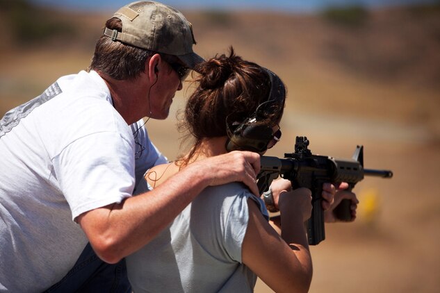 Bob Smith, an instructor with the Anti-terrorism Center on Ford Island and Kaneohe resident, helps his daughter shoot during a recreational fire event at the Kaneohe Bay Range Training Facility, Aug. 9, 2013. (U.S. Marine Corps photo by Lance Cpl. Suzanna Knotts)