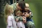 Army Sgt. 1st Class William Petit, Michigan Army National Guard, hugs his children at a deployment ceremony for the Headquarters, Headquarters Detachment, 210th Military Police Battalion February 15, 2012. The 72 members of the 210th are departing for their deployment to Afghanistan.