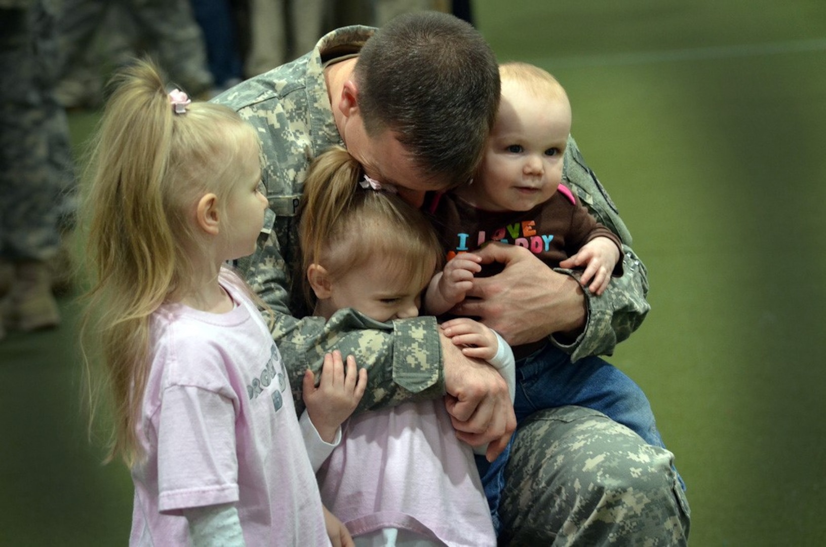 Army Sgt. 1st Class William Petit, Michigan Army National Guard, hugs his children at a deployment ceremony for the Headquarters, Headquarters Detachment, 210th Military Police Battalion February 15, 2012. The 72 members of the 210th are departing for their deployment to Afghanistan.