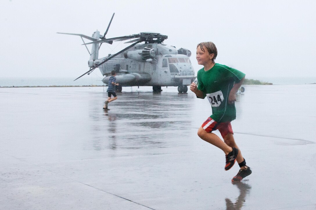 Noah Allen, 10, runs along the flight line during the Keiki Tradewind Triathlon, Aug. 10, 2013. The event was changed to a biathlon due to excess water from heavy rainfall. (U.S. Marine Corps photo by Lance Cpl. Nathan Knapke)
