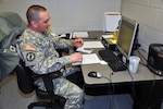 Army Staff Sgt. Jared Stewart, an employee assistance noncommissioned officer, edits a military member's résumé. Stewart helps service members and their spouses find jobs and assist them with writing résumés, preparing for interviews, and job placement.