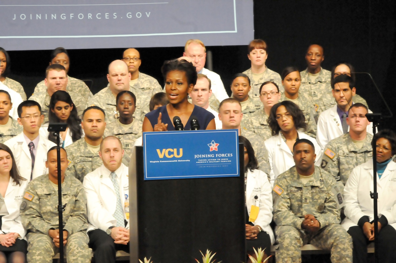 First Lady Michelle Obama speaks to Soldiers and civilians gathered at Virginia Commonwealth University's Singleton Center for the Performing Arts to announce a joint initiative to enhance support for military members and veterans with Traumatic Brain Injury and Post-Traumatic Stress Disorder. The initiative boasts new efforts to bolster education, pursue groundbreaking research and share information and best practices among various colleges and universities.