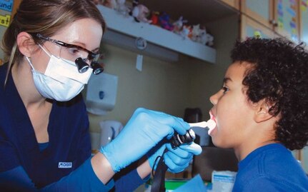 Army Capt. Martha Mitchell, a dentist at the U.S. Army Garison-Stuttgart Dental Clinic, examines 7-year-old Parker Weedon's teeth during a visit to his second-grade classroom at Robinson Barracks Elementary School. Assistance for family dental care up to $4,000 per case is now available through Army
Emergency Relief under new guidelines that expand eligible categories.