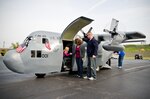 Family members of Kentucky Air Guard members exit the 123rd Airlift Wing's Mini C-130 after an orientation "flight" Oct. 23, 2011, during the wing's annual Family Day celebration in Louisville, Ky. The Mini C-130 is a scale replica of the Hercules transport aircraft, built on a golf-cart chassis and propelled by a 27-horsepower gasoline motor. Although incapable of flight, it can reach speeds of up to 20 mph, features working propellers, a functional cargo door, a UHF radio, a high-powered stereo system and seating for up to a dozen passengers. The replica was built from scratch by the Airmen of the Kentucky Air Guard's 123rd Maintenance Squadron.