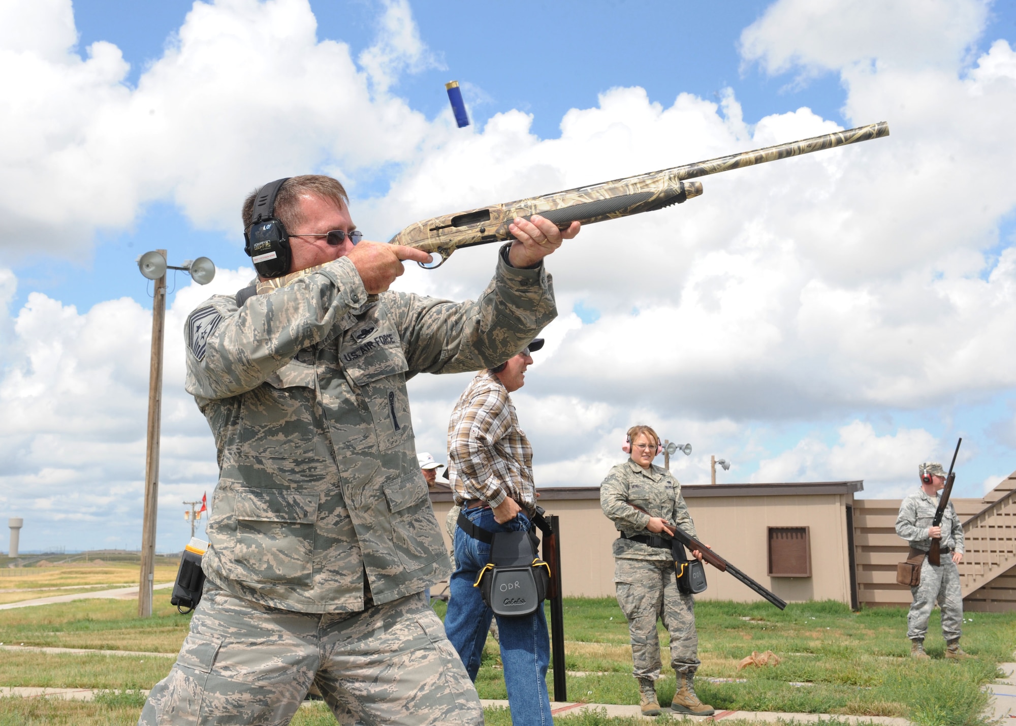 Chief Master Sgt. Kevin Peterson, 28th Bomb Wing command chief, alongside 10 other competitors, shoots at the Trap and Skeet range on Ellsworth Air Force Base, S.D. Aug. 9, 2013. During the Command Chief Challenge, Airmen competed in striking as many clay pigeons as possible. (U.S. Air Force photo by Airman 1st Class Rebecca Imwalle/Released)
