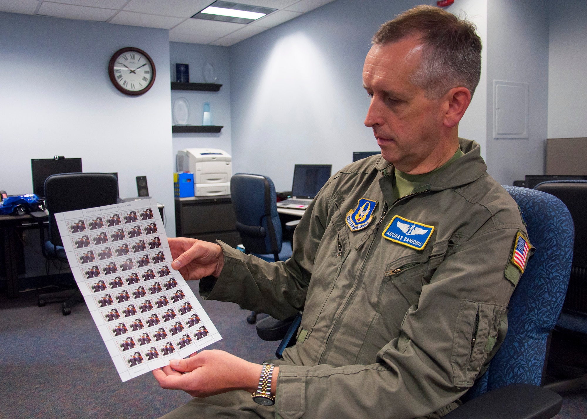 Lt. Col. (Dr.) Arunas Banionis, a flight surgeon with the 446th Aerospace Medicine Squadron, displays a page of Lithuanian stamps, Aug. 11. Banionis created the design, which placed first in the Lithuanian Post Postage Stamps Design Contest in May. July 20 marked the 80th Anniversary of the Flight of Darius and Girėnas, the first transatlantic flight flown by Lithuanian-born pilots, which was his inspiration for the design. Banionis has a Lithuanian background and grew up with admirations in stamp collecting and aviation. (U.S. Air Force Reserve photo/Master Sgt. Jake Chappelle)