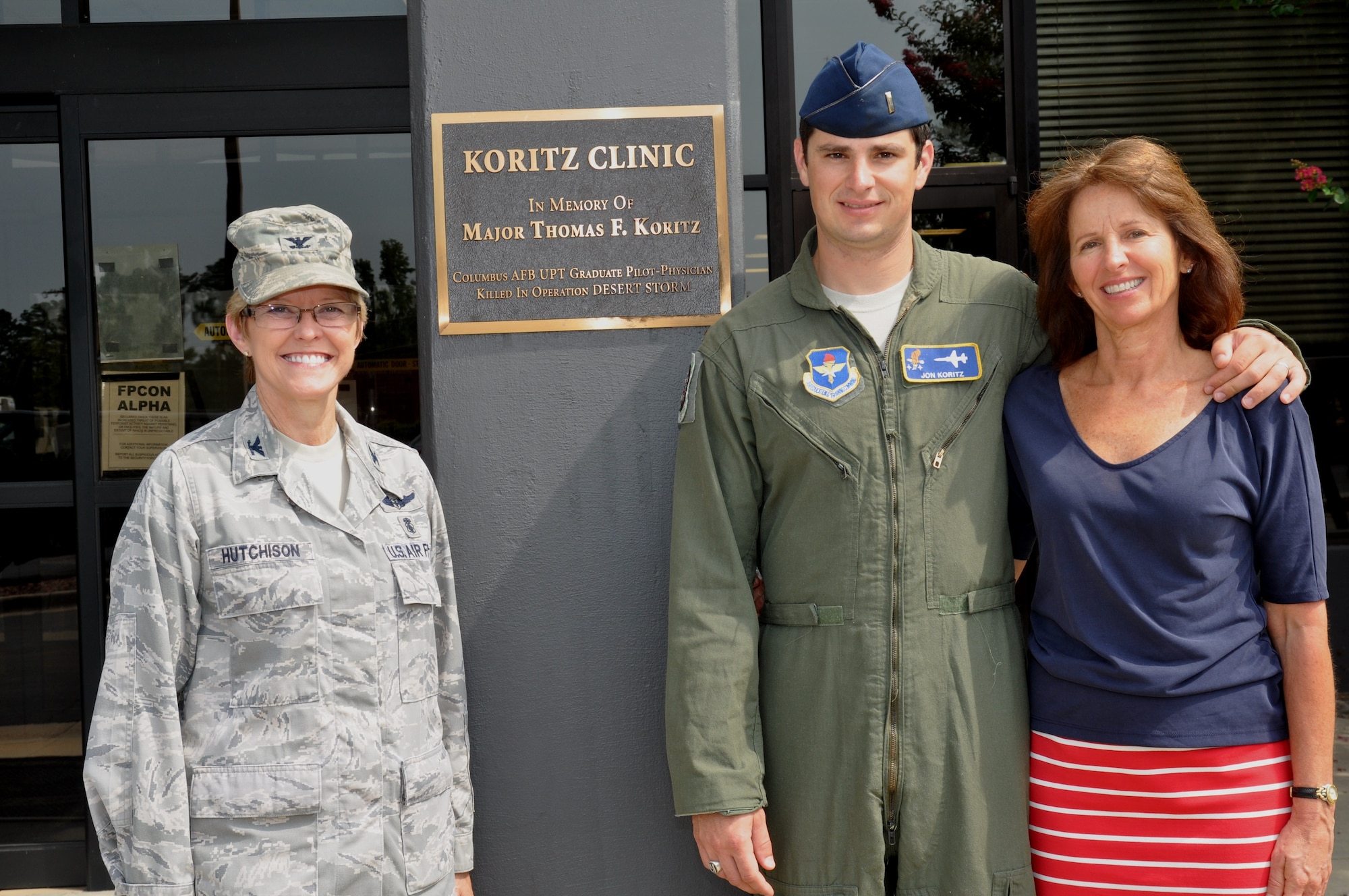 Col. Billye Hutchison,14th Medical Group Commander, poses for a photo with 2nd Lt. Jon Koritz, Specialized Undergraduate Pilot Training Class 13-13 Graduate, and his mother Julianne Koritz outside of the Koritz Clinic August 3. The Koritz Clinic was renamed in 2008 in honor of Maj. Thomas Koritz after he was Killed in Action during the second night of combat in Operation Desert Storm in 1991. (U.S. Air Force Photo/Sonic Johnson)